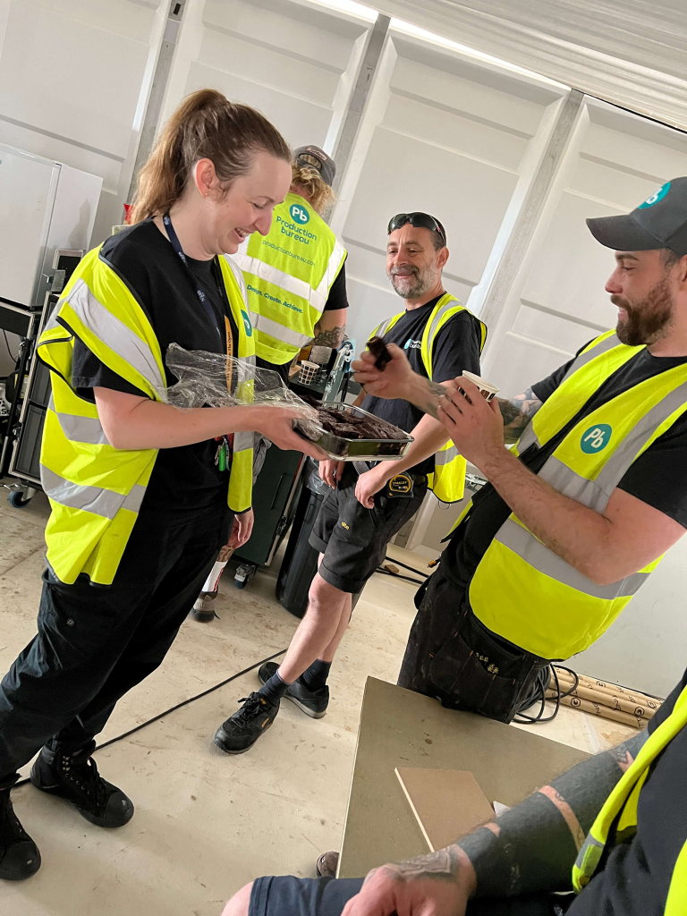 staff wearing high vis safety ppe and eating brownies